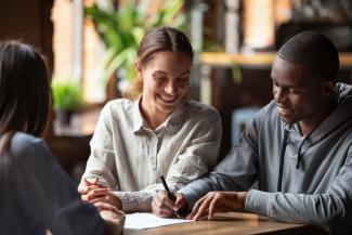 2 women and man working together at a table